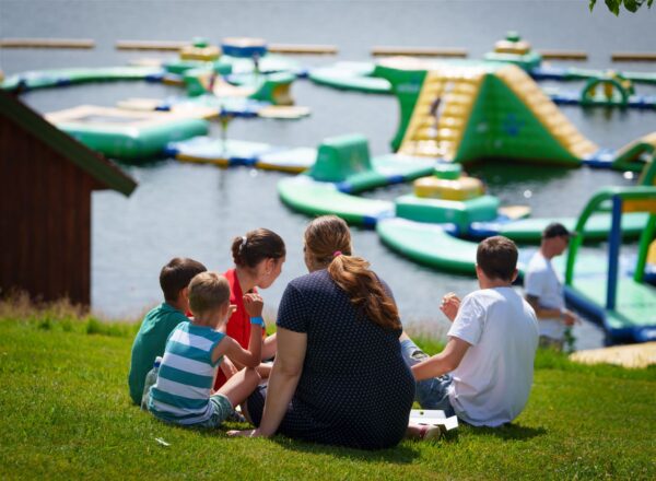 Folk sitter på gresset ved Hulfjell Vannpark